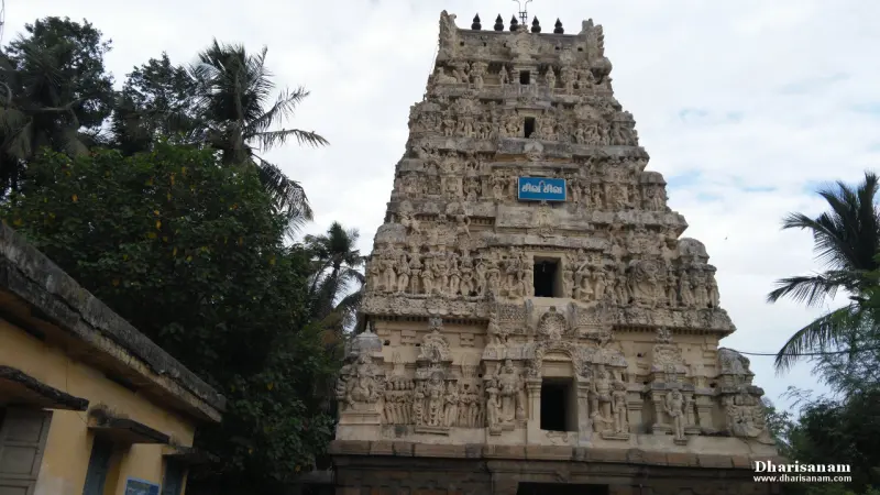 Weathered stone tower with carved tiers, palm trees on both sides