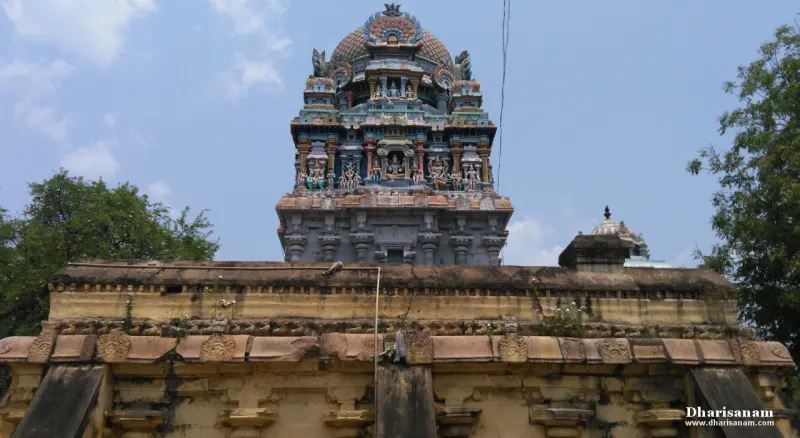 Colourful tiered tower with sculptures above a weathered stone wall