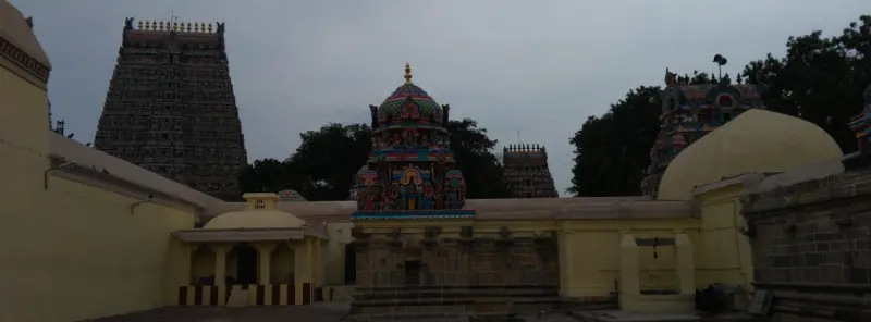 Dark gopuram and painted vimana rising over yellow walls