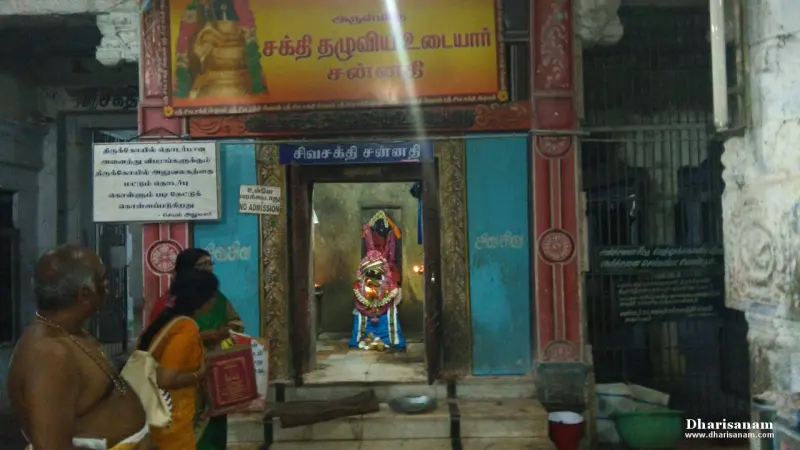 A shrine doorway with a Tamil name board above it and a garlanded image inside.